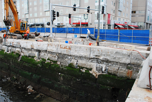Re-laying the original sea wall's giant granit blocks